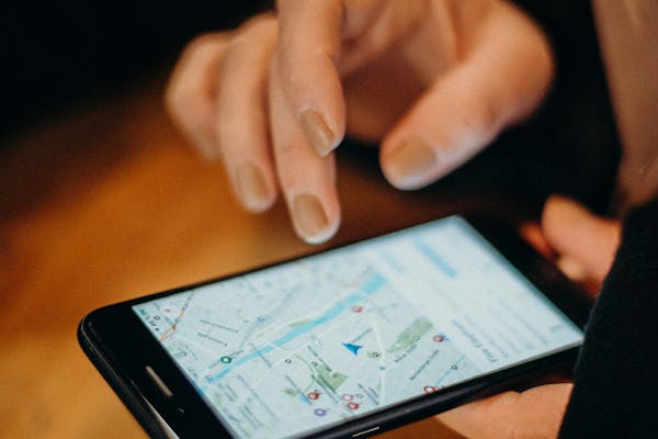 Close-up of a hand using a smartphone displaying a map for navigation.